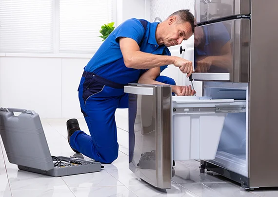 Technician working on a refrigerator, emphasizing the key benefits of their repair solutions.