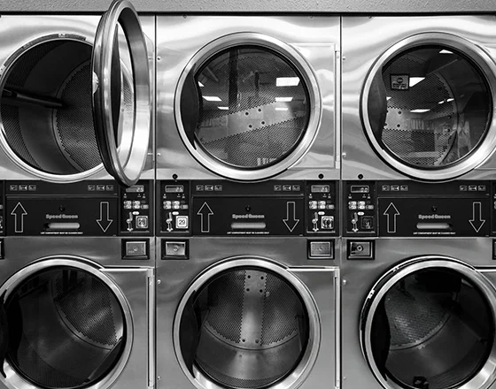 Row of commercial washing machines, illustrating commercial washer repair services in Sellersburg, IN.