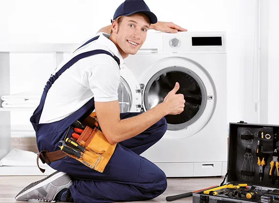 Happy technician giving a thumbs up next to a dryer, indicating expert dryer solutions and successful repair.