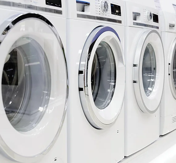 Row of industrial washing machines, illustrating industrial washer repair services in New Albany, IN.