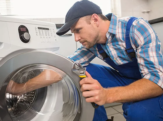 Technician repairing a dryer, emphasizing professional dryer repair services in Sellersburg, IN.