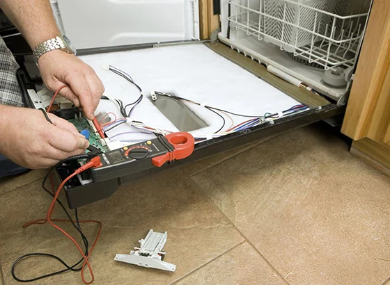 Technician repairing a dishwasher, emphasizing quick and dependable service.